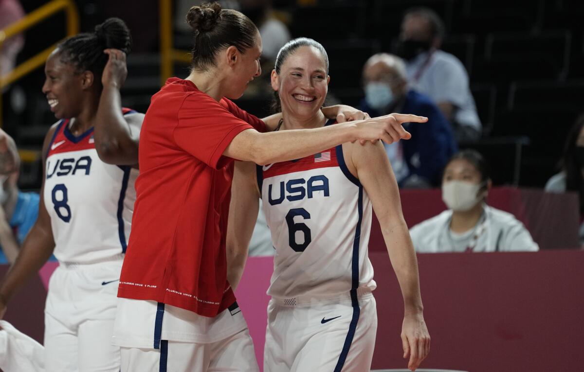 United States's Sue Bird (6), right, and teammate Diana Taurasi (12), center, celebrate after their win in the women's basketball gold medal game against Japan at the 2020 Summer Olympics, Sunday, Aug. 8, 2021, in Saitama, Japan. (AP Photo/Eric Gay)