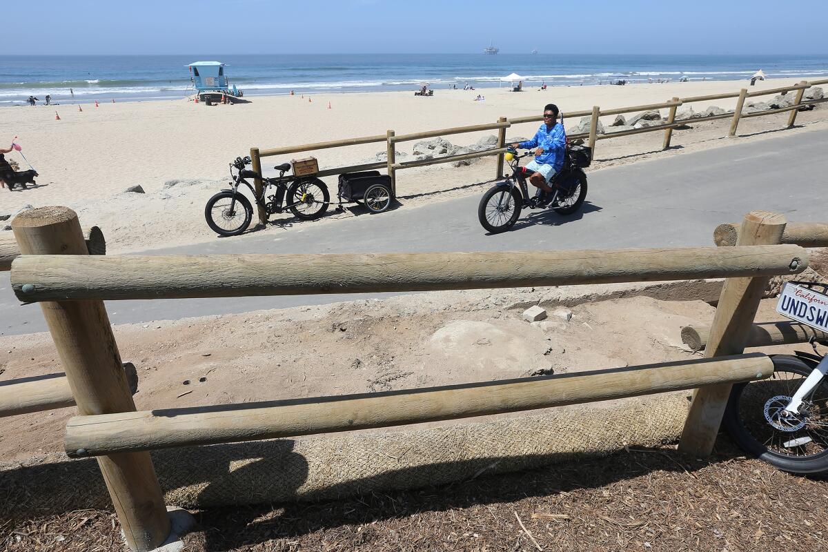 A man rides an e-bike near Bluff Top Park in Huntington Beach in 2022.
