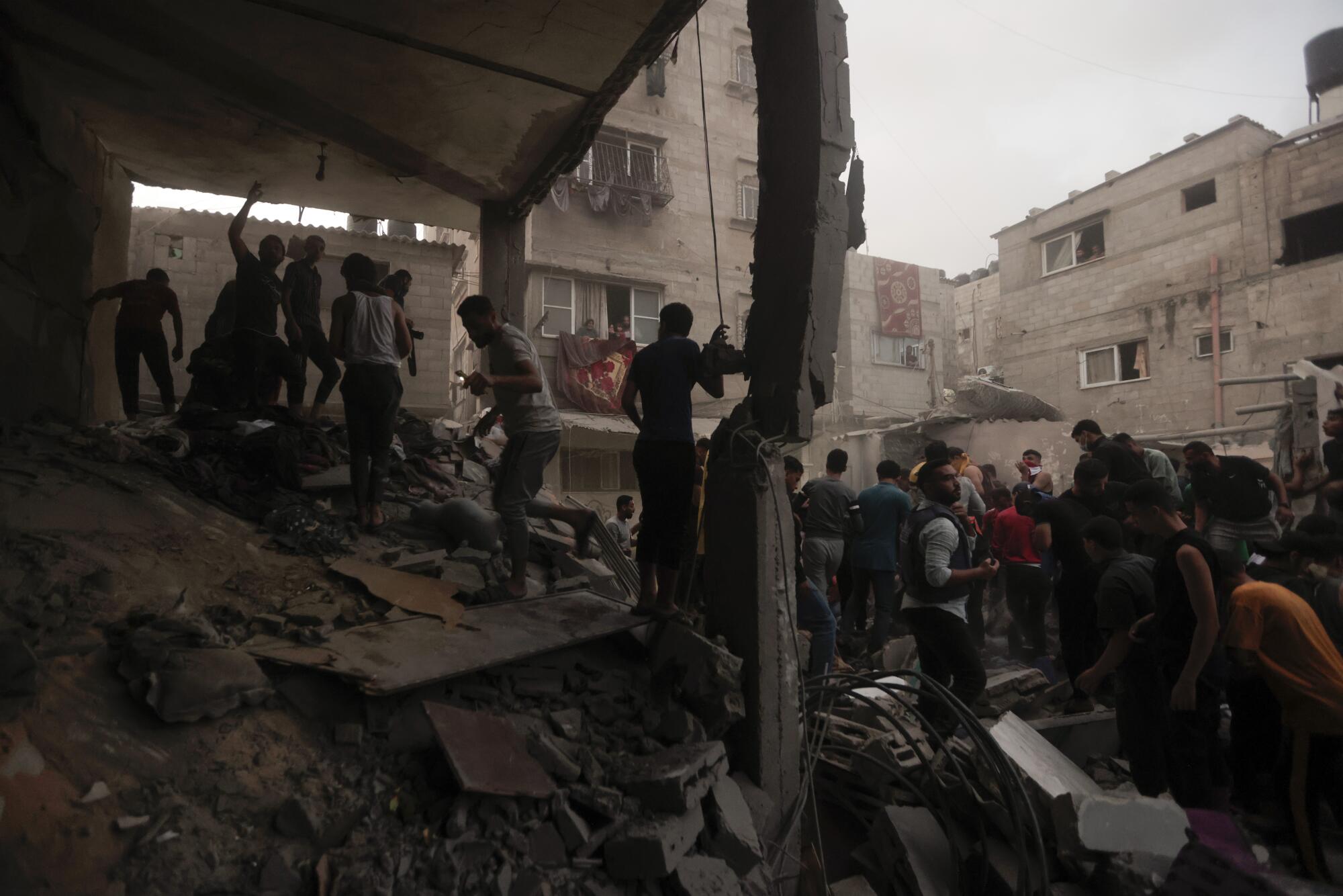 Palestinians look for survivors under the rubble of a house after an airstrike