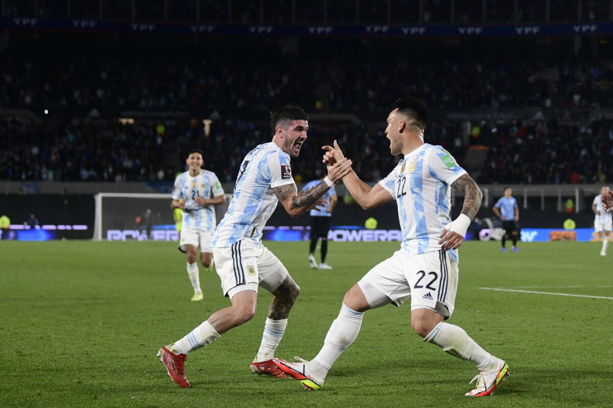 Argentina's Lautaro Martinez (22) celebrates with teammates Rodrigo De Paul after scoring his side's third goal against Uruguay during a qualifying soccer match for the FIFA World Cup Qatar 2022 in Buenos Aires, Argentina, Sunday, Oct. 10, 2021. (AP Photo/Gustavo Garello)