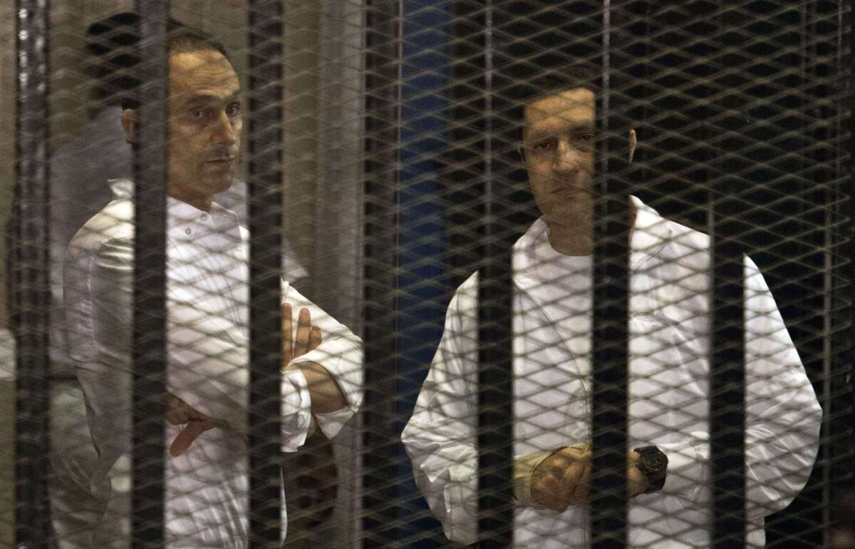 A file picture taken June 8, 2013, shows the sons of ousted Egyptian President Hosni Mubarak, Gamal, left, and Alaa, in the defendants' cage during their retrial at the Police Academy in Cairo.