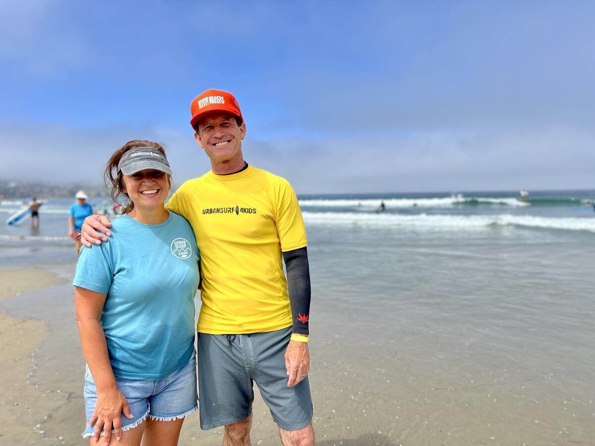 Roxanne Avant of Urban Surf 4 Kids and Mike Matey of Reef attend a July 26 beach day at La Jolla Shores.
