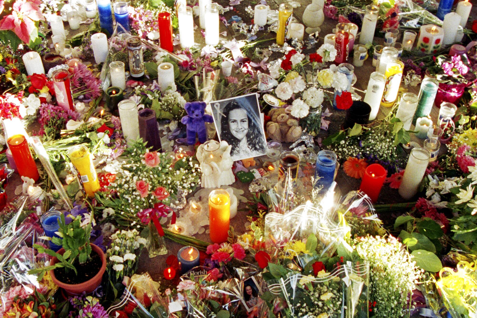 Flowers and candles surrounding a portrait of a girl