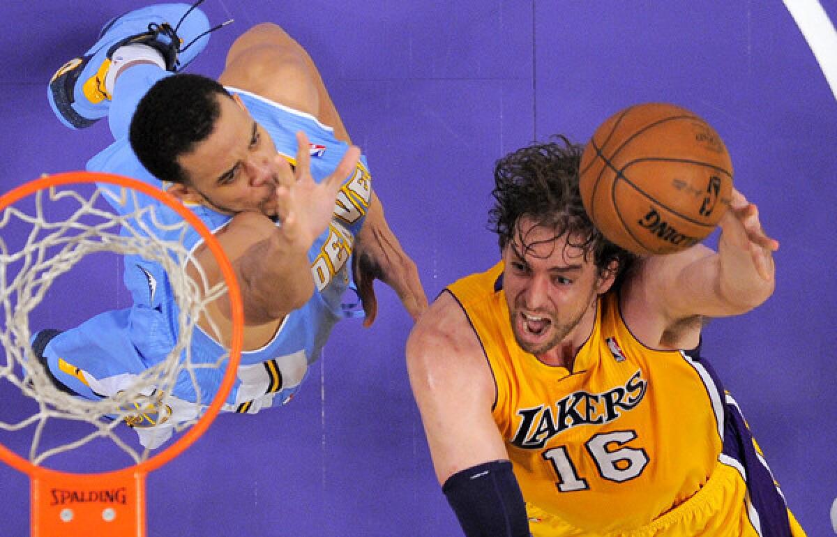 Lakers power forward Pau Gasol drives to the basket against Nuggets center JaVale McGree.
