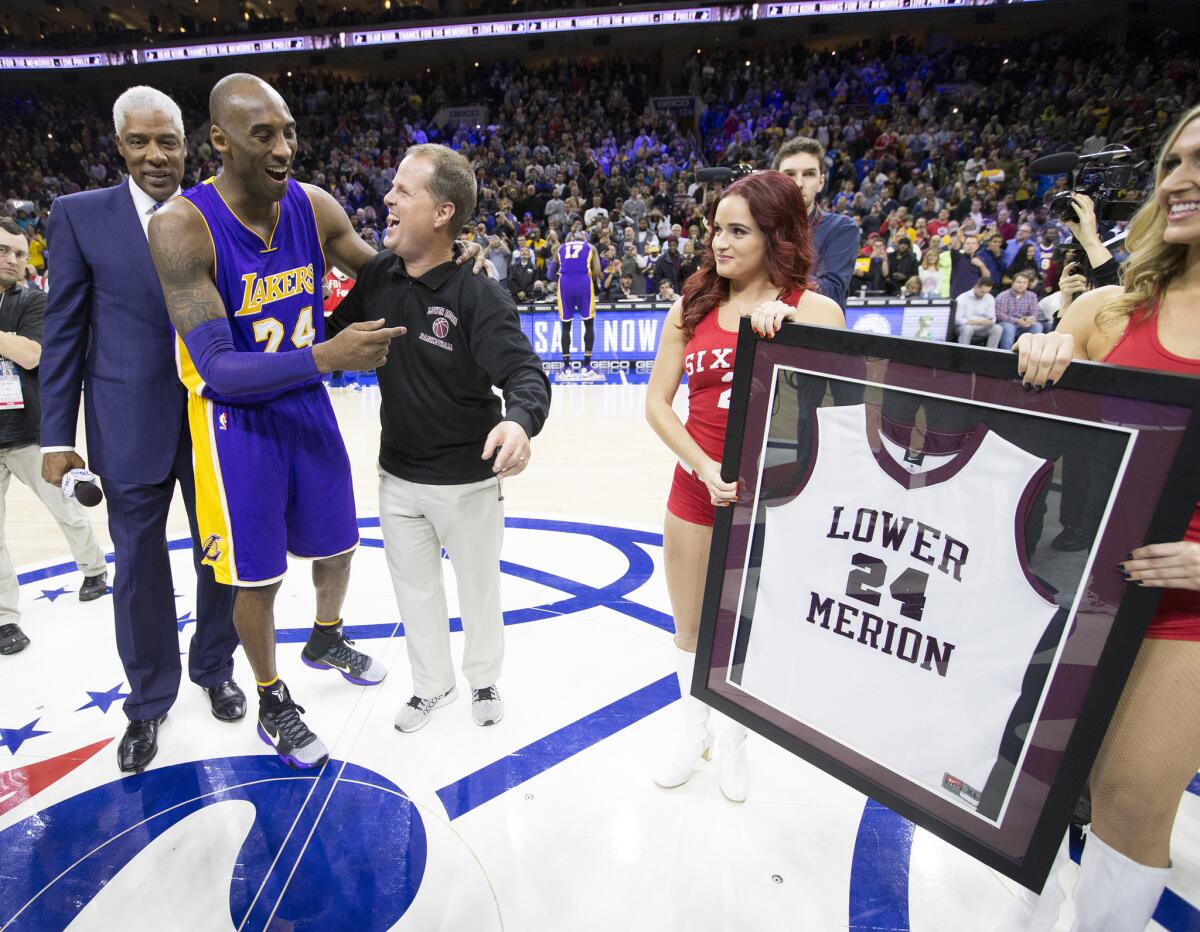Former NBA player Julius Erving, left, and Kobe Bryant's Lower Merion High School coach, Gregg Downer, present Bryant a framed jersey before a game against the 76ers.