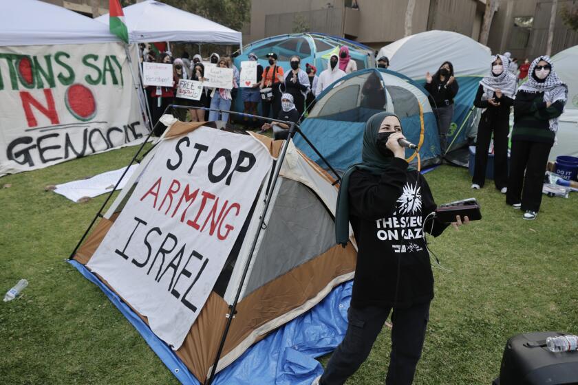 SAN DIEGO, CA - MAY 01, 2024: A pro-Palestinian protester uses a microphone to lead chants as UCSD students protest the war in Gaza at an encampment they set up at UCSD in San Diego on Wednesday, May 01, 2024.