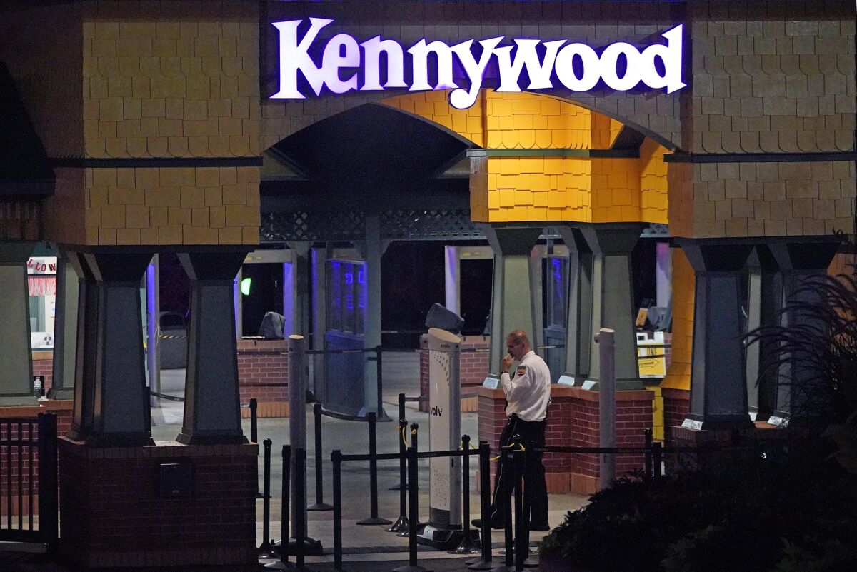 A Kennywood Park security guard stands at the main entrance to the amusement park in West Mifflin, Pa., early Sunday, Sept 25, 2022. Pennsylvania police and first responders have descended on the amusement park southeast of Pittsburgh following reports of shots fired inside the attraction, which was kicking off a Halloween-themed festival. (AP Photo/Gene J. Puskar)