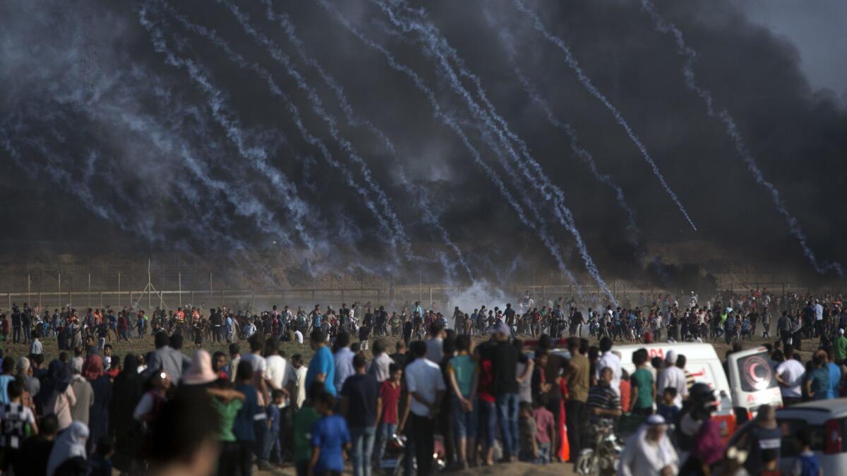 Tear gas canisters fired by Israeli troops rain down on Palestinians during a July 13 protest at the Gaza Strip's border with Israel.