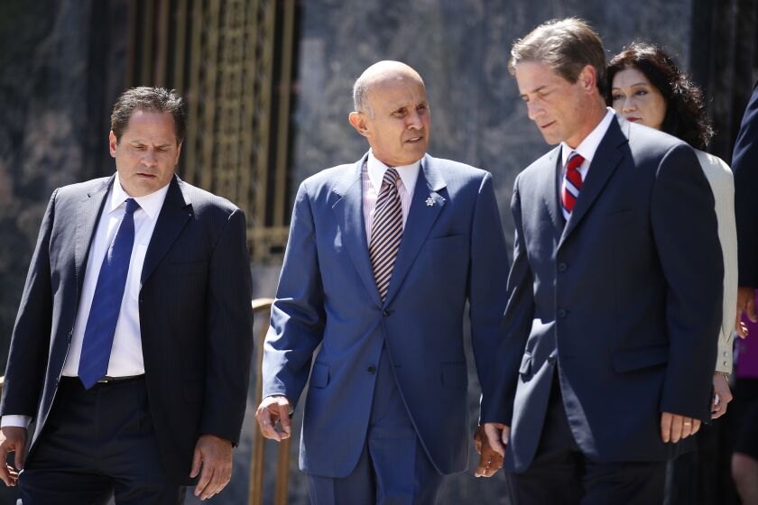 Flanked by his attorneys, former Los Angeles County Sheriff Lee Baca leaves federal court in Los Angeles earlier this year after being arraigned on charges of conspiracy, obstructing justice and lying to the federal government.