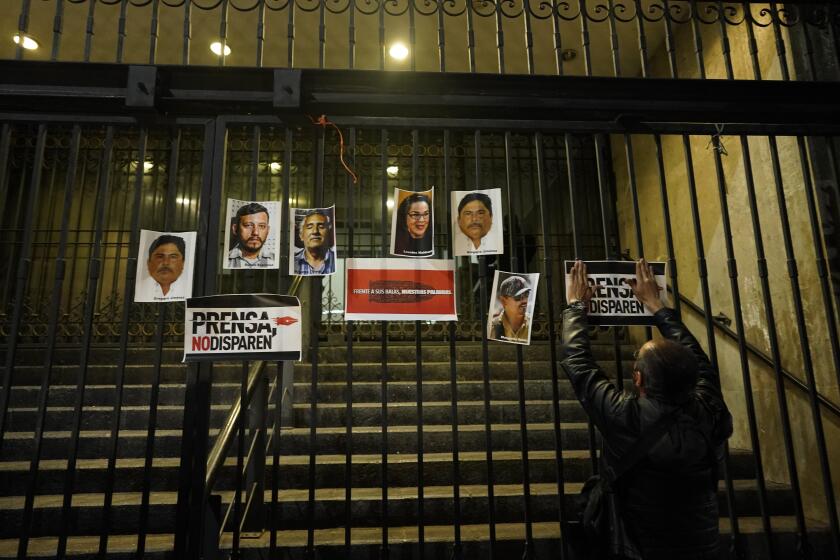 A person posts photos of slain journalists during a vigil to protest the murder of journalist Heber Lopez, on the gate of Mexico's Attorney General's office in Mexico City, Monday, Feb. 14, 2022. Lopez, who was the director of the online news site Noticias Web, was shot to death Thursday, Feb. 10, in the coastal city of Salina Cruz, in Oaxaca state. The Committee to Protect Journalists declared these six past weeks the "deadliest for the Mexican press in over a decade." (AP Photo/Eduardo Verdugo)