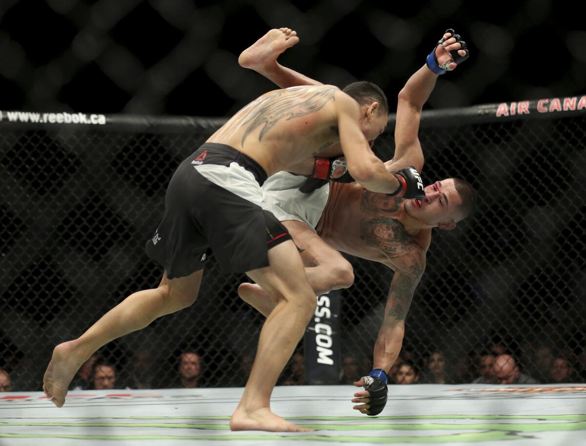 Max Holloway knocks Anthony Pettis to the mat during their fight at UFC 206 in Toronto.