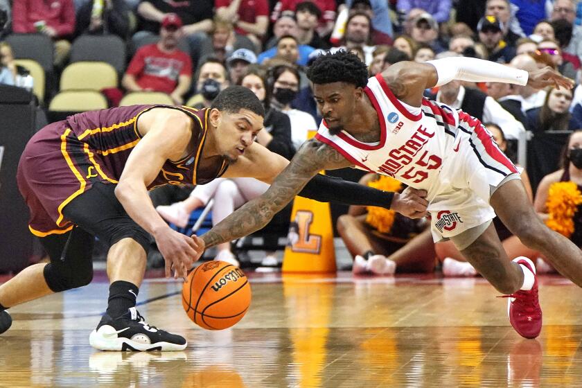 Loyola Chicago's Lucas Williamson, left, and Ohio State 's Jamari Wheeler (55) scramble for the ball during the second half of a college basketball game in the first round of the NCAA tournament in Pittsburgh, Friday, March 18, 2022. Ohio State won 54-41. (AP Photo/Gene J. Puskar)