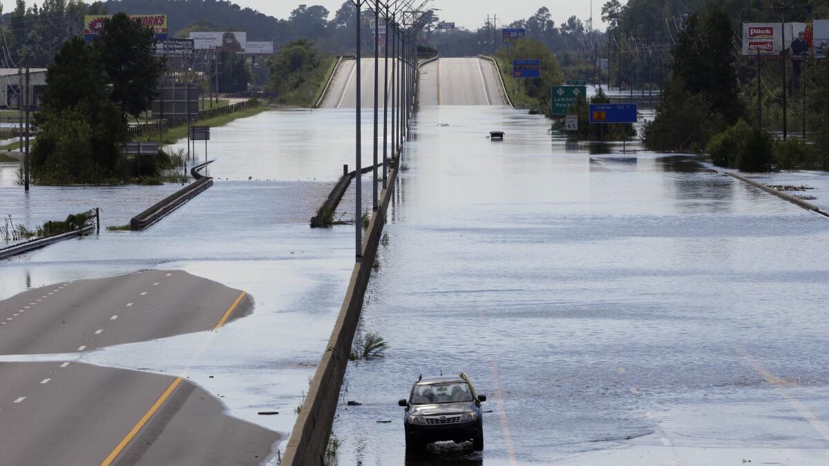A flooded vehicle sits on a closed section of Interstate 95 in Lumberton, N.C., on Monday.