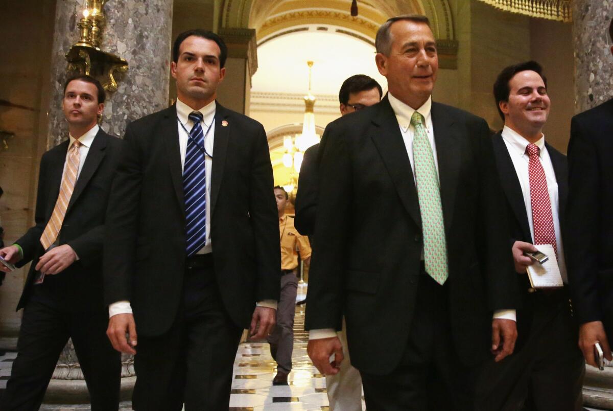 Speaker of the House John A. Boehner (R-Ohio), second from right, walks through the Capitol in Washington.