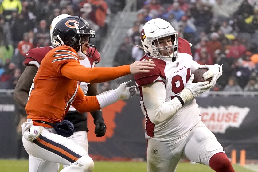 Arizona Cardinals defensive end Zach Allen advances the ball after intercepting a pass by Chicago Bears quarterback Andy Dalton ,left, during the second half of an NFL football game Sunday, Dec. 5, 2021, in Chicago. The Cardinals won 33-22. (AP Photo/David Banks)
