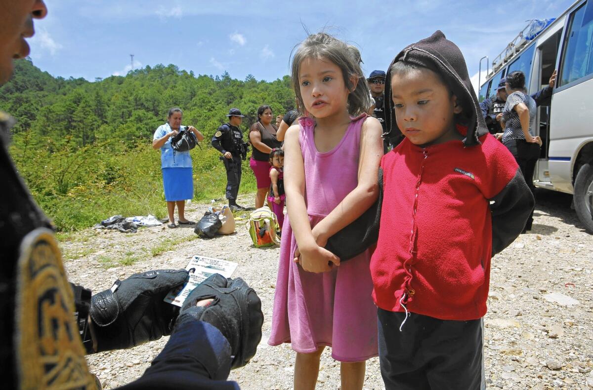 Two siblings in Ocotepeque, Honduras, speak to an official whose questions were designed to evaluate whether children were being smuggled to the U.S. as part of a summer wave of illegal immigration.