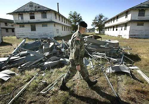 Army National Guard Staff Sgt. Tom Murotake walks past disassembled metal heating ducts that were suspended along the ceilings of the spartan wood structures that housed more than a million men over the decades. Ongoing demolitions of the buildings unearthed 25 wallets dating back to World War II and Korean War years.