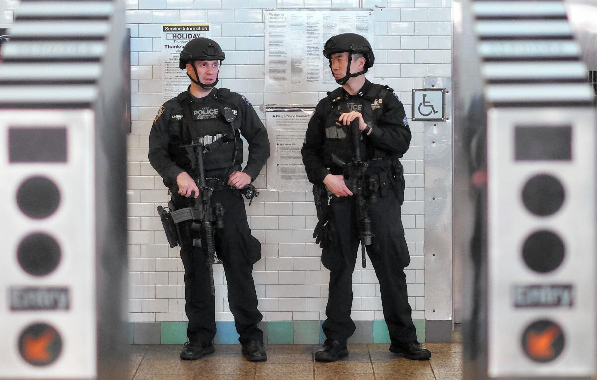New York police officers guard a subway entrance at Times Square on Wednesday, five days after the Paris attacks.
