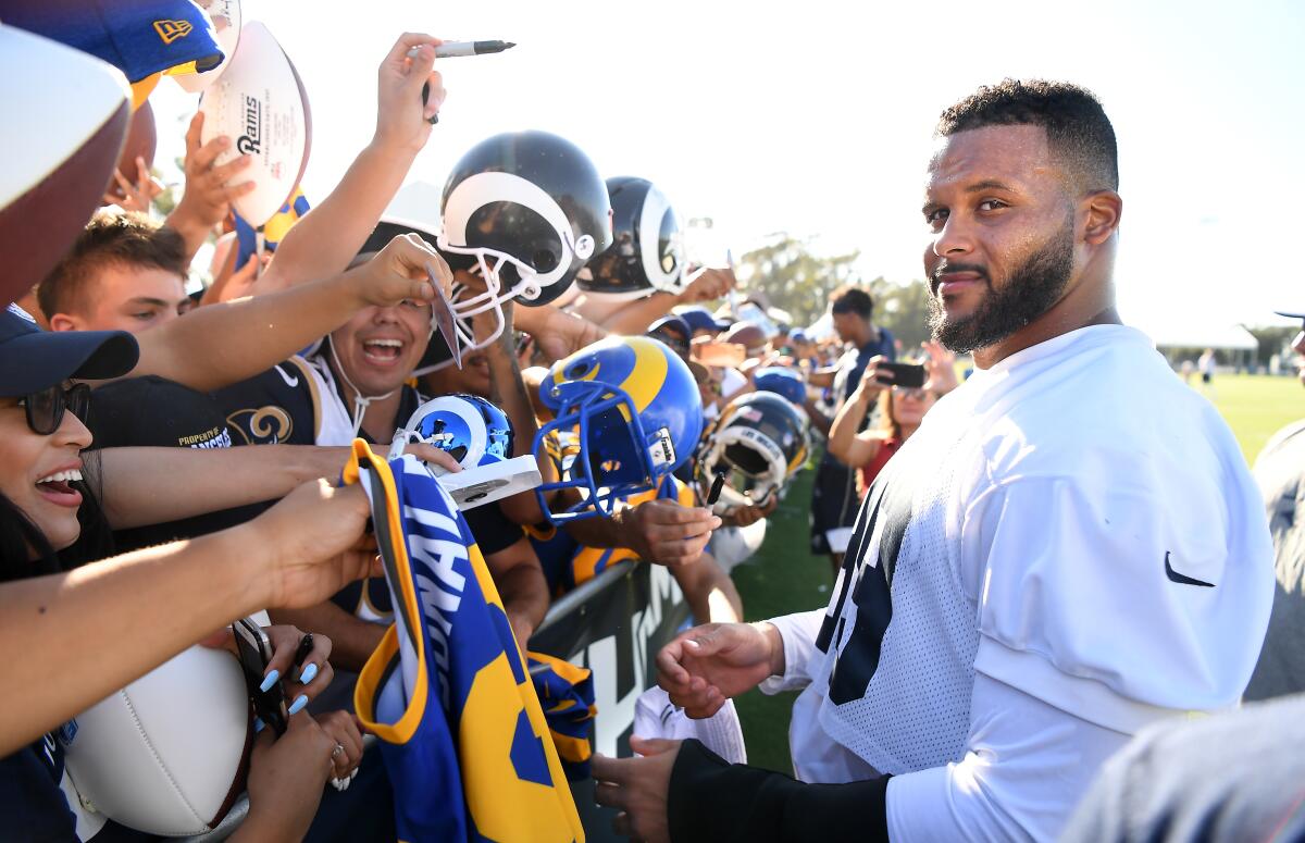 Rams defensive tackle Aaron Donald signs autographs during the first day of training camp at UC Irvine on Saturday. 