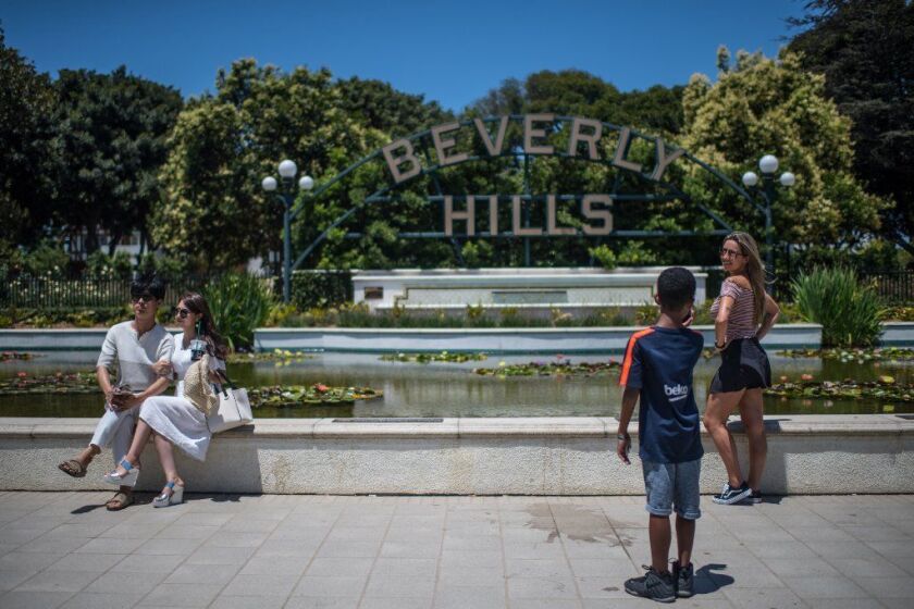 BEVERLY HILLS, CA - July 24, 2018 Bernardo Orlandi photographs Marcela Nani at Beverly Gardens Park near Rodeo Drive in Beverly Hills on July 24, 2018. (Gabriel S. Scarlett / Los Angeles Times)