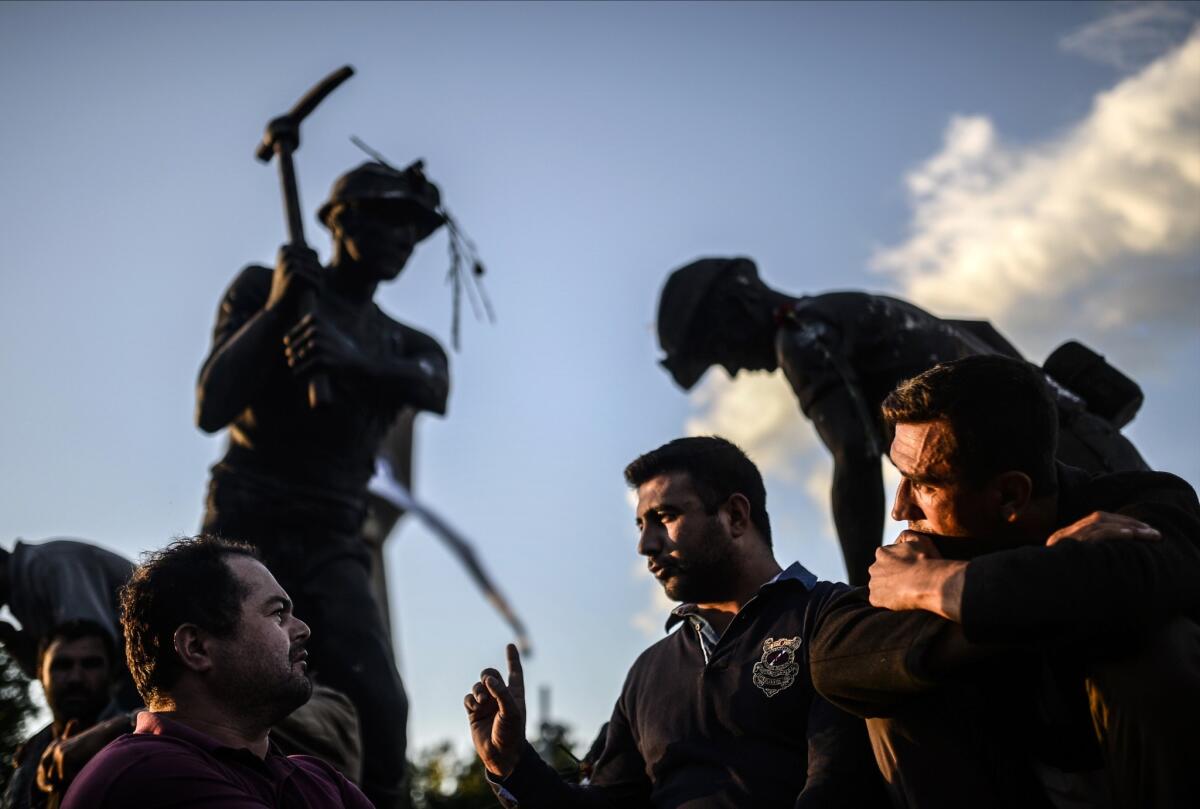 Turkish miners meet in front of a statue in the western town of Soma, four days after an underground explosion took 301 lives.