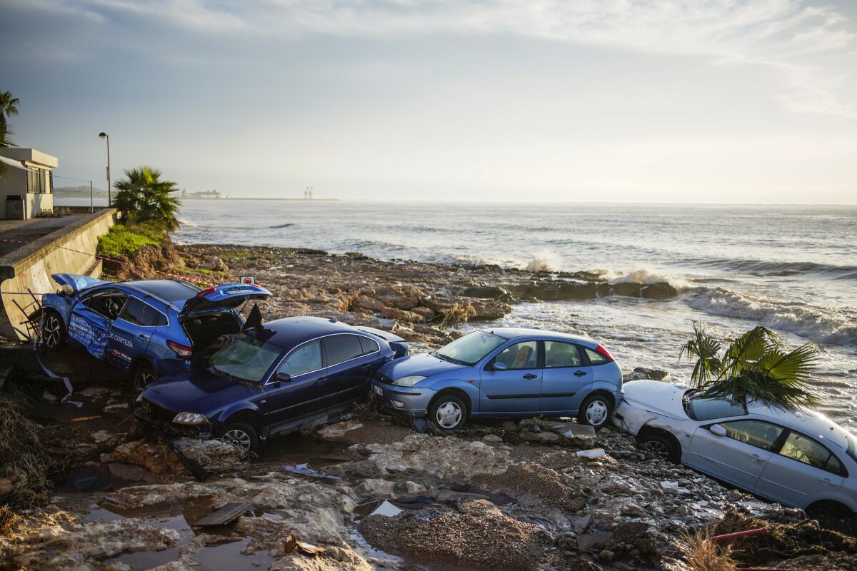 Wrecked cars stuck in the shore of the seaside town of Alcanar, in northeastern Spain, Thursday, Sept. 2, 2021. A downpour Wednesday created flash floods that swept cars down streets in the Catalan town of Alcanar. Most of mainland Spain is under alert for heavy rains. (AP Photo/Joan Mateu Parra)