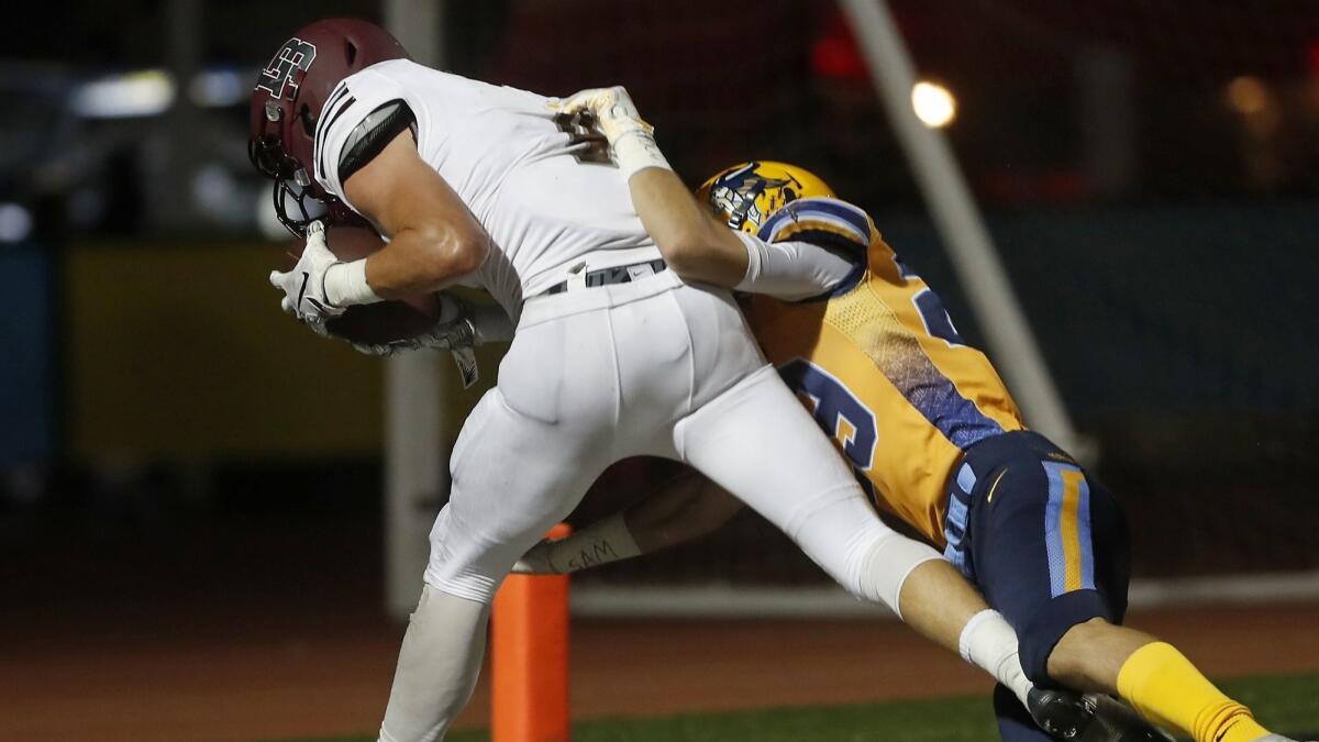 Laguna Beach High wide receiver Sean Nolan, left, scores a second touchdown while being covered by Marina's Dillion Blake during the first half on Friday.