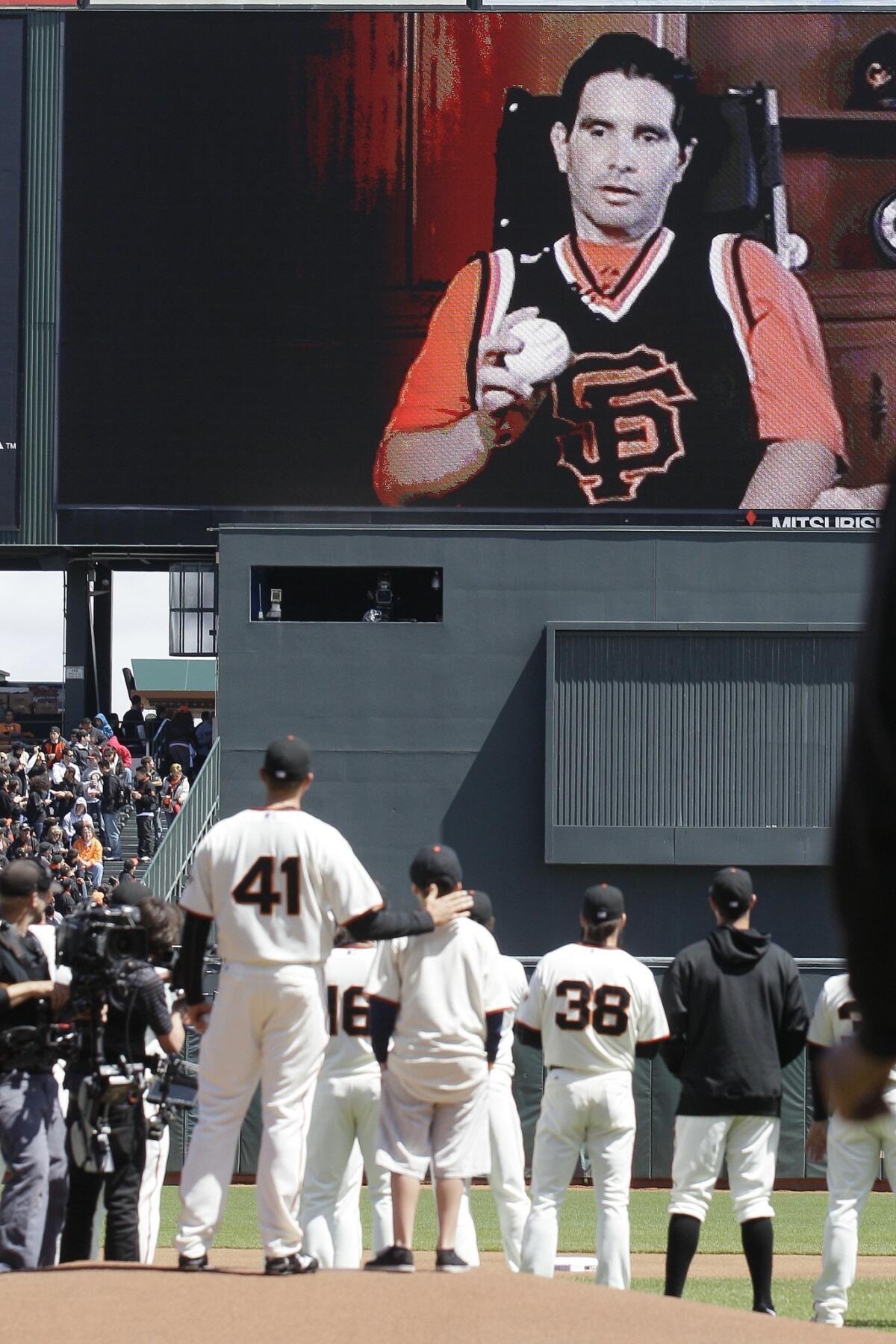 Bryan Stow appears on the big screen before the San Francisco Giants' 2012 home opener. Tyler Stow threw out the first pitch.
