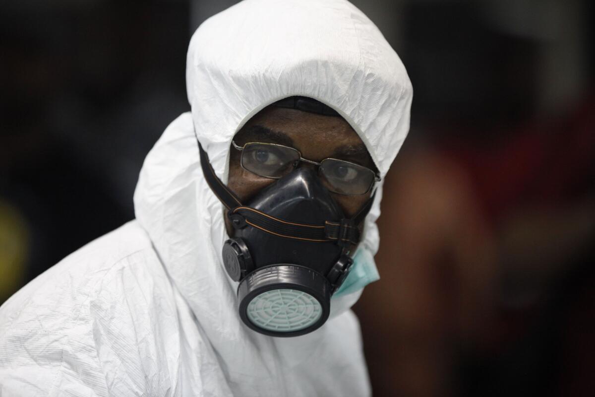 A Nigerian health official wears protective gear at the arrivals hall of Murtala Muhammed International Airport in Lagos.