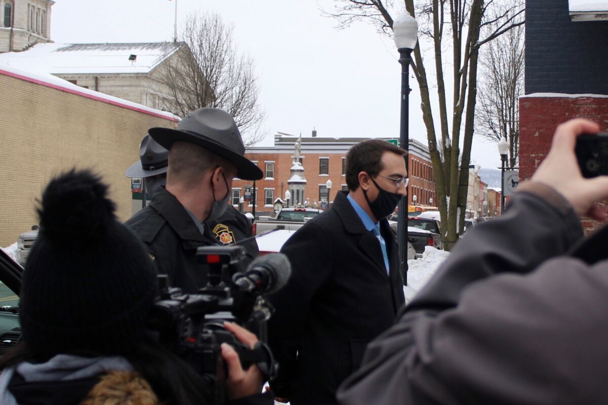 FILE - In this Feb. 3, 2021 file photo, Bradford County, Pa., District Attorney Chad Salsman is escorted into Magisterial District Court, in Towanda, Pa. A judge in Bradford County imposed the sentence of 18 months to 5 years on Friday, July 9, 2021 for former District Attorney Chad M. Salsman. He'd emphatically denied the allegations before pleading guilty in May to witness intimidation, promoting prostitution and obstruction of justice. (Brianne Ostrander/The Daily Review via AP)