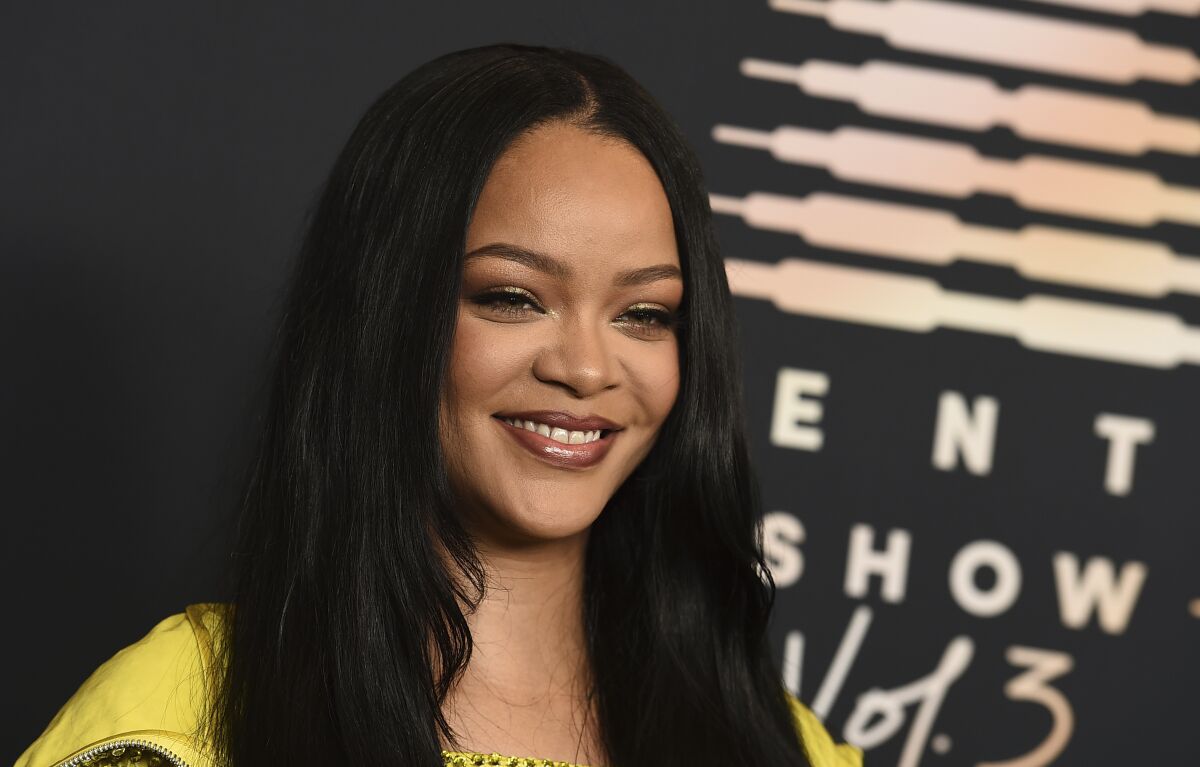 Rihanna smiles at an event.