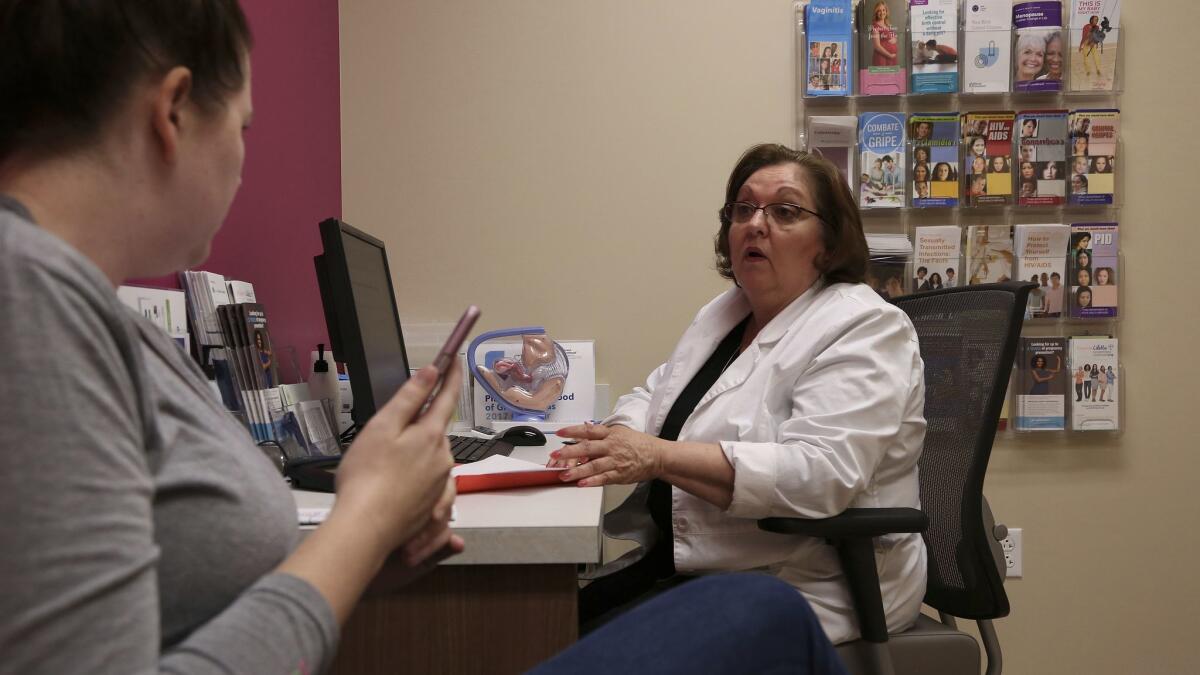 Vivian Bigelow, a nurse practitioner at a Planned Parenthood health center in Plano, Texas, consults with a patient.