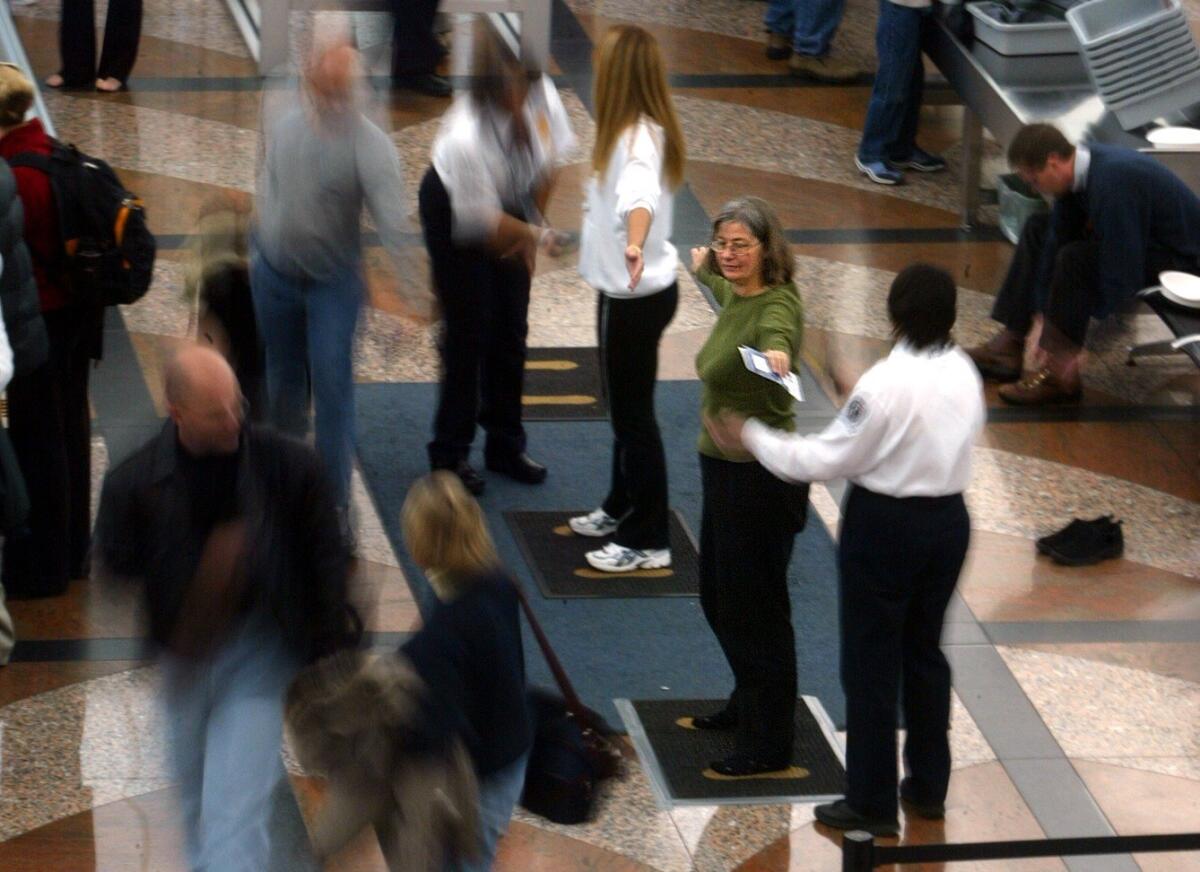 Transportation Security Administration agents screen travelers at Denver International Airport in 2003.