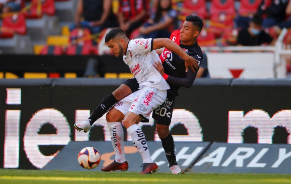 Ían Torres (d) de Atlas disputa el balón con Matías Barbona (i) de Xolos
