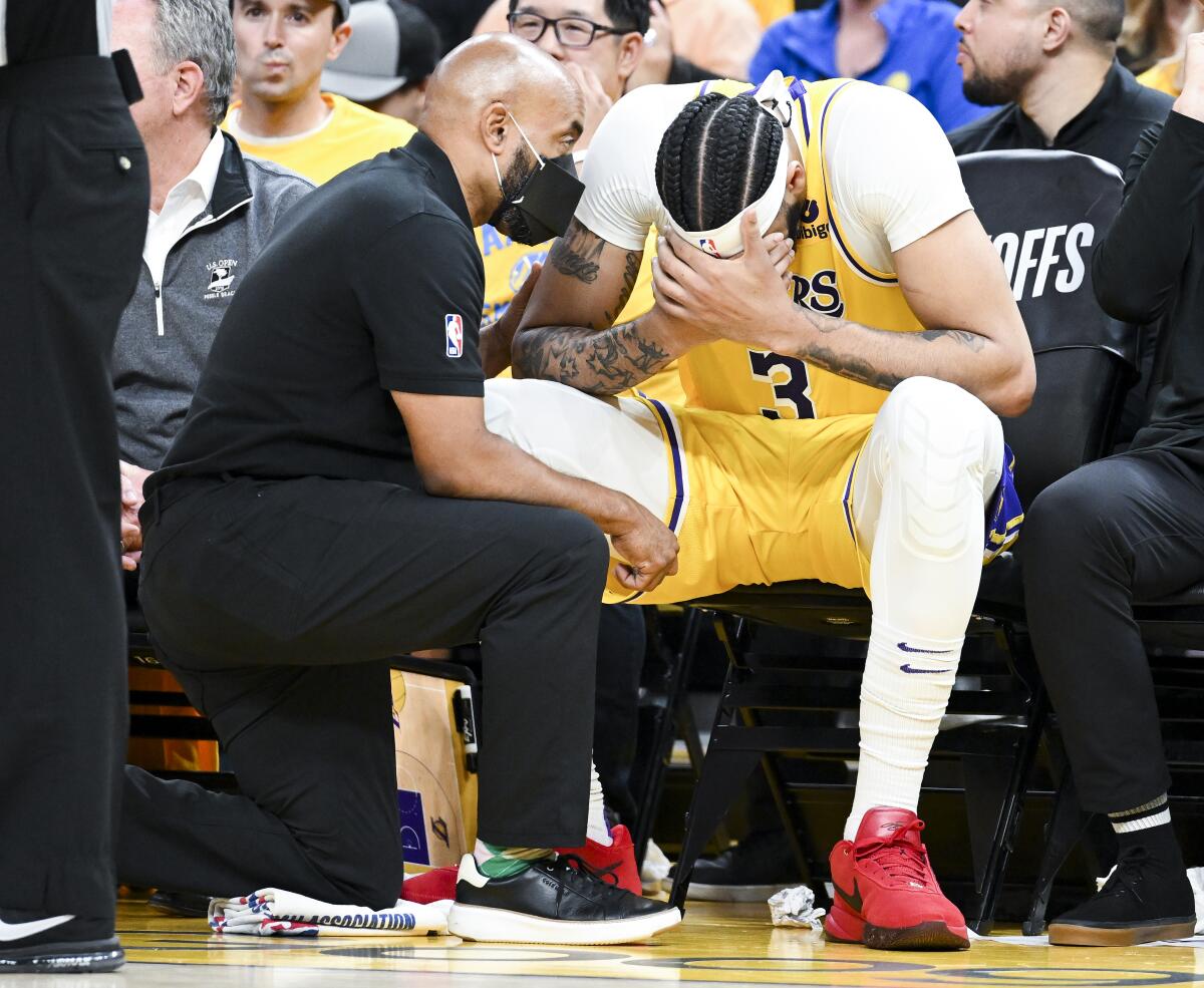 Forward Anthony Davis is checked by a member of the Lakers staff while sitting on the bench in the fourth quarter of Game 5.