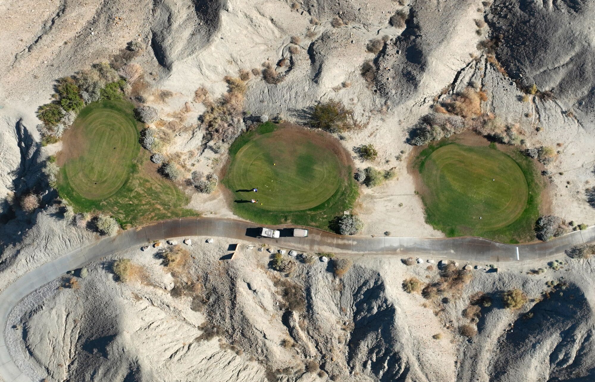 Golfing tee boxes are built into the desert