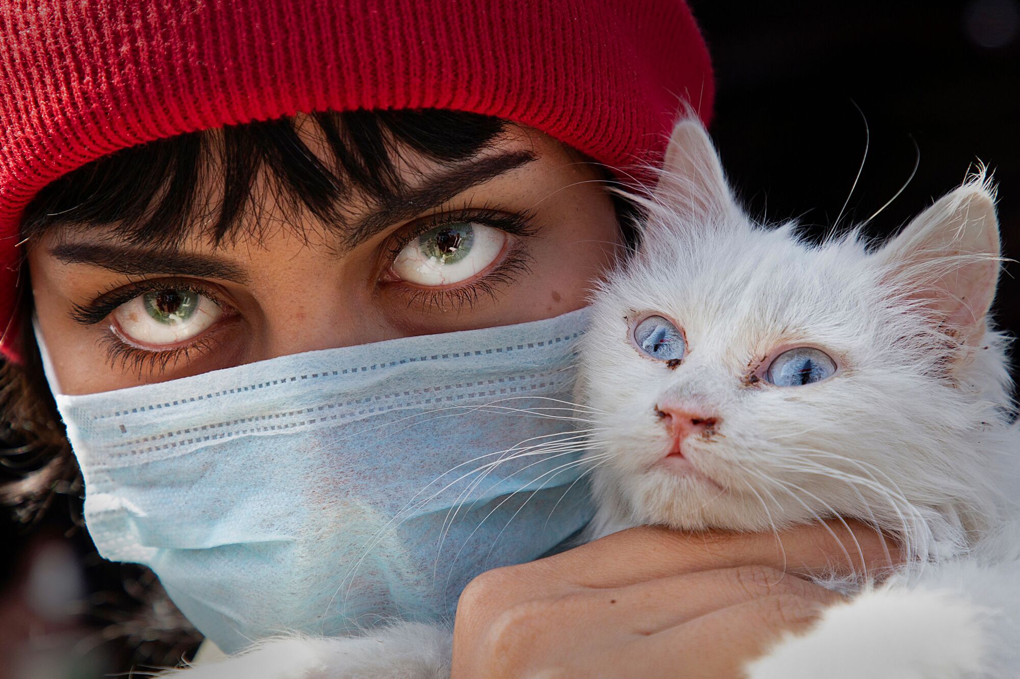 IRAQ: A woman wearing a protective mask and colored contact lenses holds her cat as she poses for a picture during a protest against corruption in the Iraqi government in the southern city of Basra on Feb. 27.
