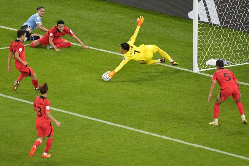 South Korea's goalkeeper Kim Seung-gyu dives to save a goal attempt by Uruguay's Darwin Nunez