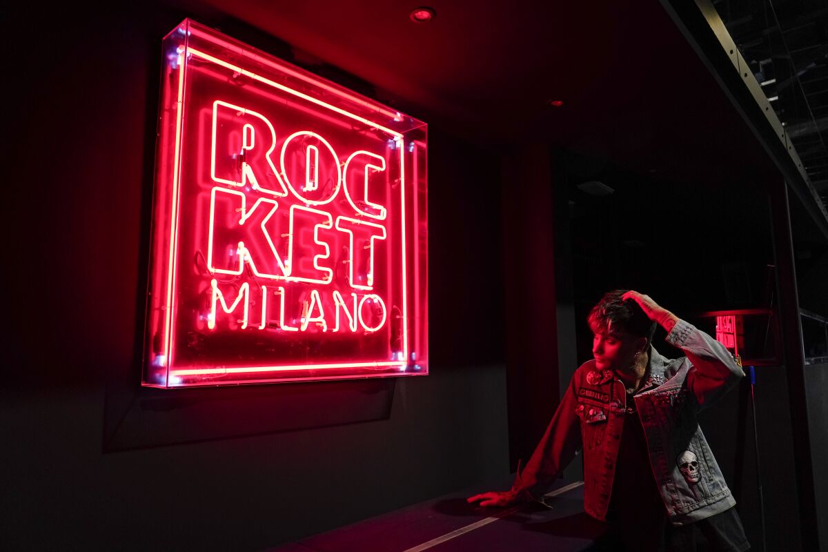 Italian Dj Richey V, real name Francesco Orcese, looks at a neon sign inside Rocket Club, in Milan, Saturday, Sept. 25, 2021. Richey V, who created "Void" which briefly became the unmissable appointment for a Thursday night in Milan, and is perhaps the most famous techno club in the region, said the early days of lockdown was like a psychological holiday from his busy calendar. With Italy’s vaccination campaign now advanced, the government has finally given the green light for nightclubs to reopen this weekend. It's been a long wait. They are recommending that venues can open at 50% capacity indoors, and 70% in the open air. (AP Photo/Alberto Pezzali)