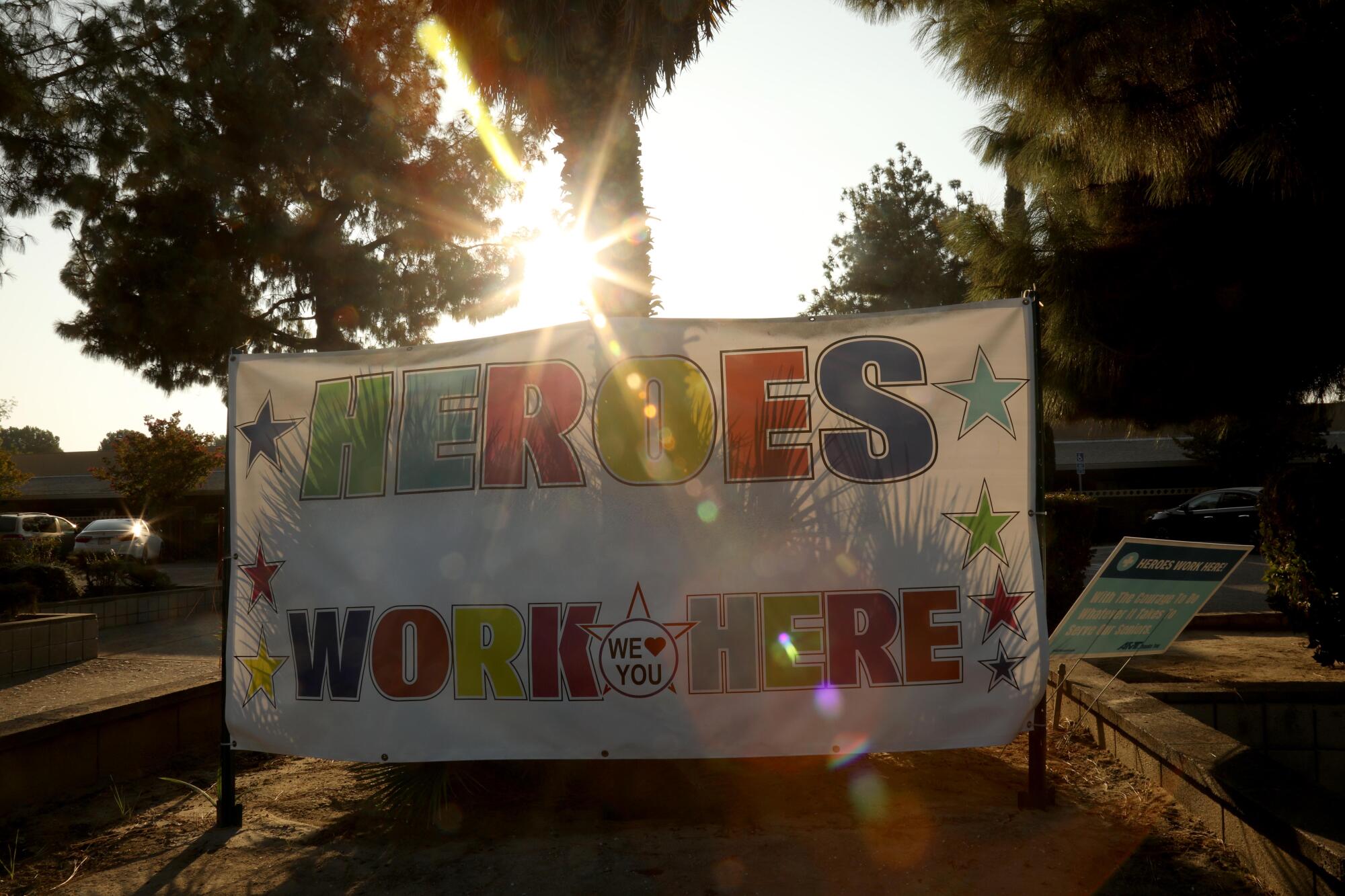 A sign in front of Kingston Healthcare Center in Bakersfield reads "Heroes work here." 
