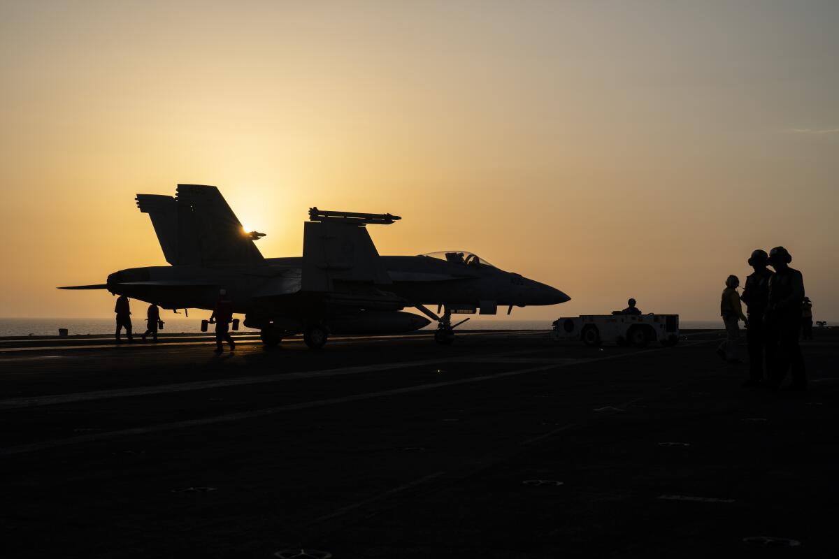 A fighter jet on the deck of a U.S. aircraft carrier.