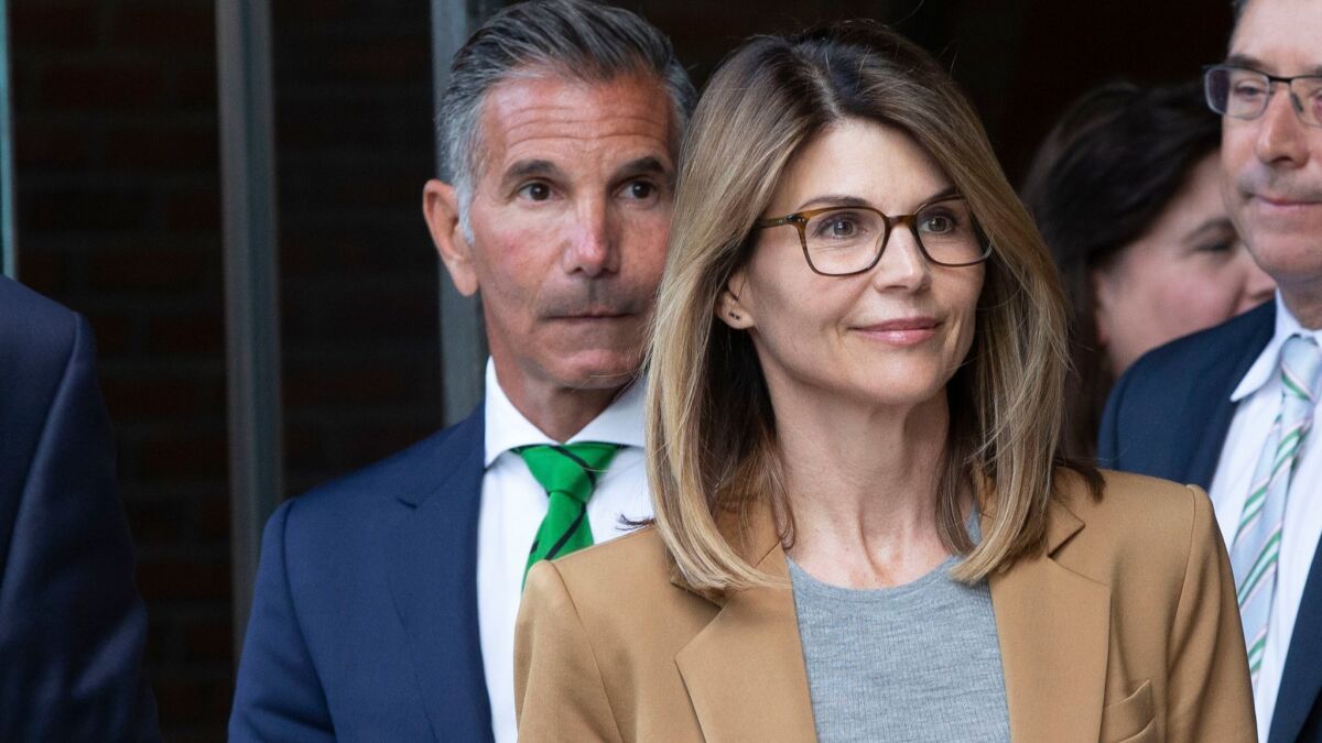 U.S. actress Lori Loughlin (R) and husband Mossimo Giannulli (L) leave the John J. Moakley Federal Court House after facing charges in a nationwide college admissions cheating scheme in Boston, Massachusetts.