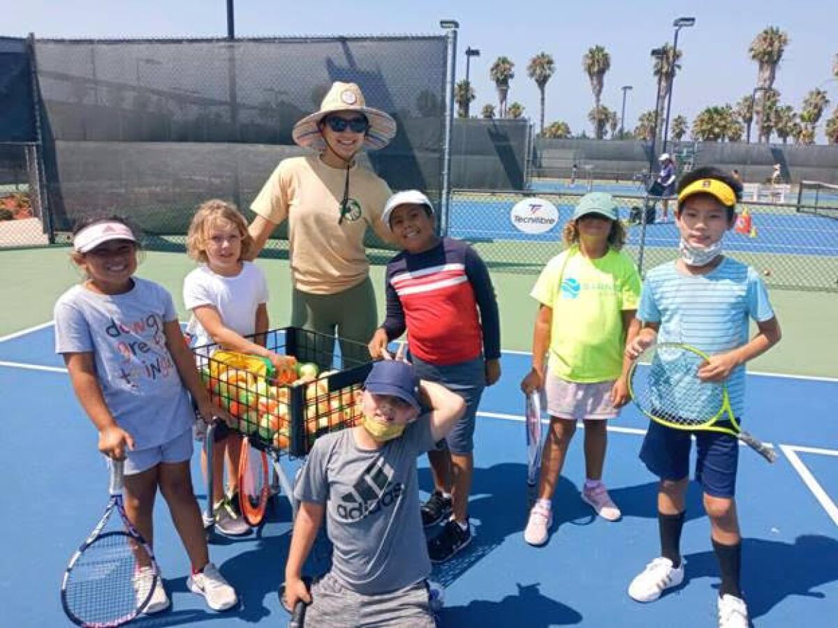 City Heights kids enjoying tennis on a court in August.