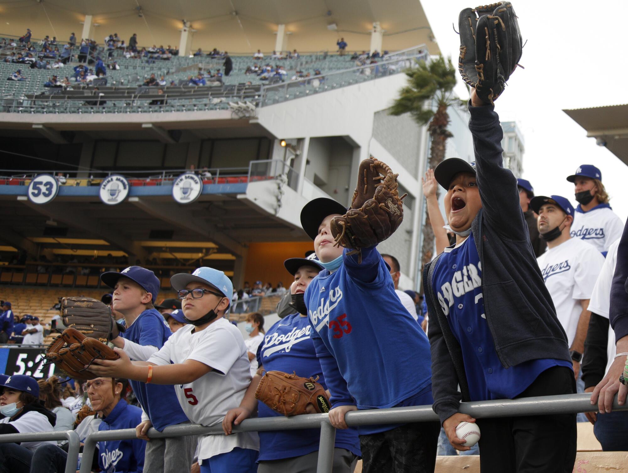  Dodgers fans cheer for a ball during batting practice.