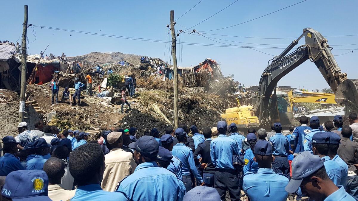Police officers secure the perimeter at the scene of a garbage landslide, as excavators aid rescue efforts, on the outskirts of Ethiopia's capital, Addis Ababa.