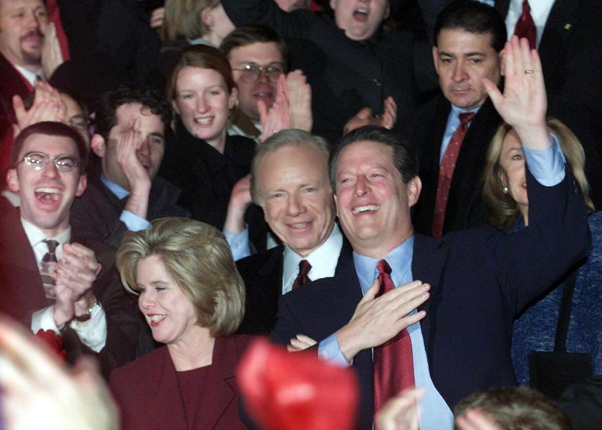 Vice President Al Gore, center, his running mate Joe Lieberman to his right and Gore's wife, Tipper, lower left, greet supporters following Gore's concession speech on Dec. 13, 2000.
