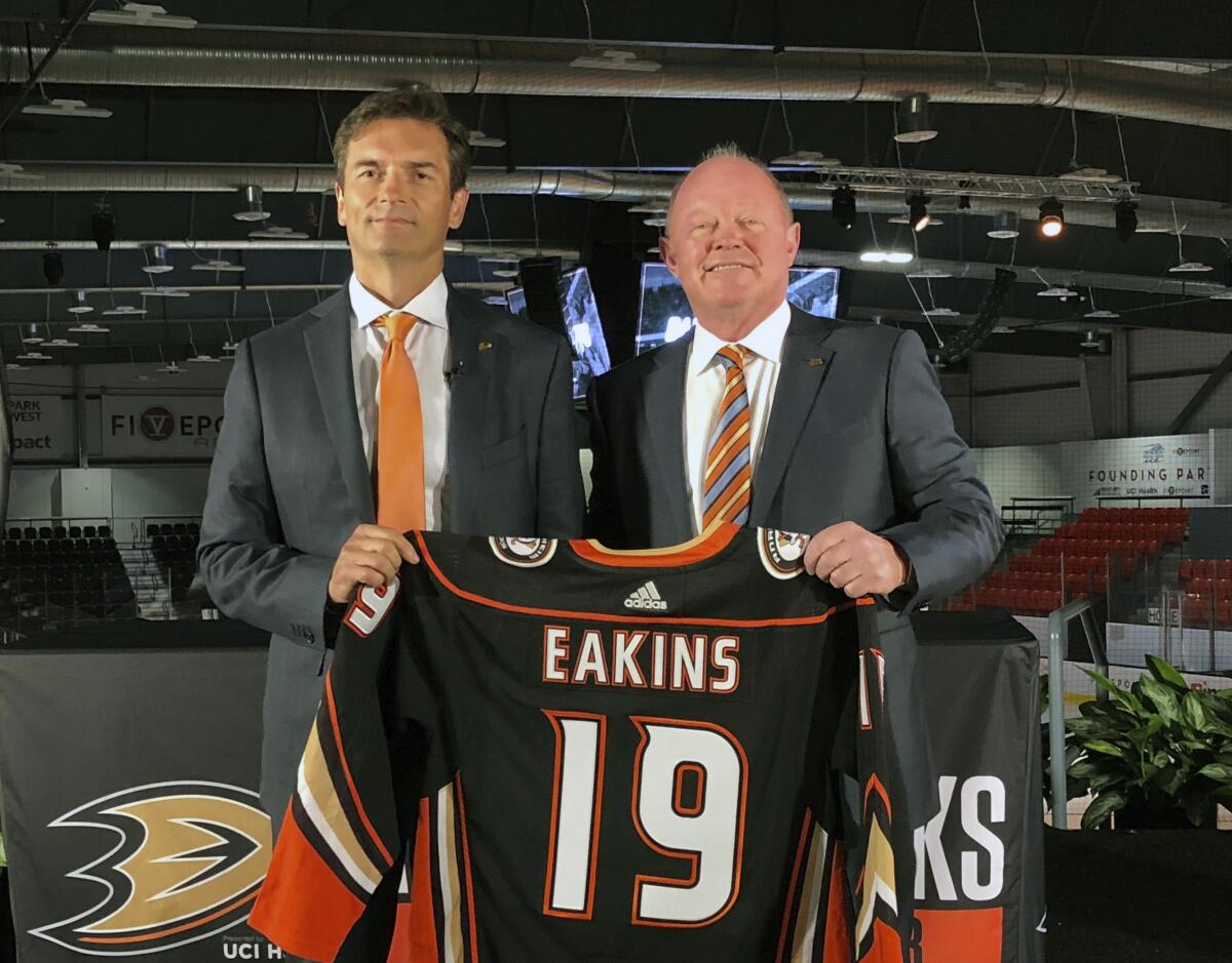 Ducks coach Dallas Eakins and general manager Bob Murray pose with a jersey.