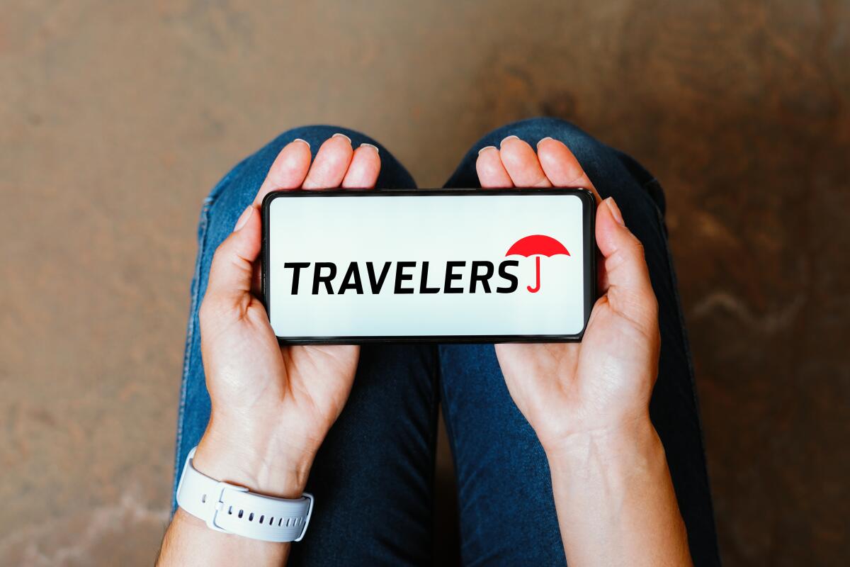 The Travelers Insurance logo is displayed on a smartphone screen.