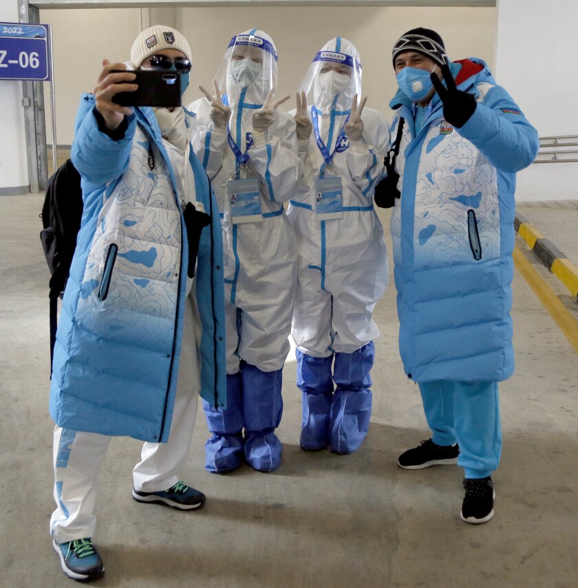 Two journalists from Azerbaijan pose for a selfie with two Beijing Olympic transport workers