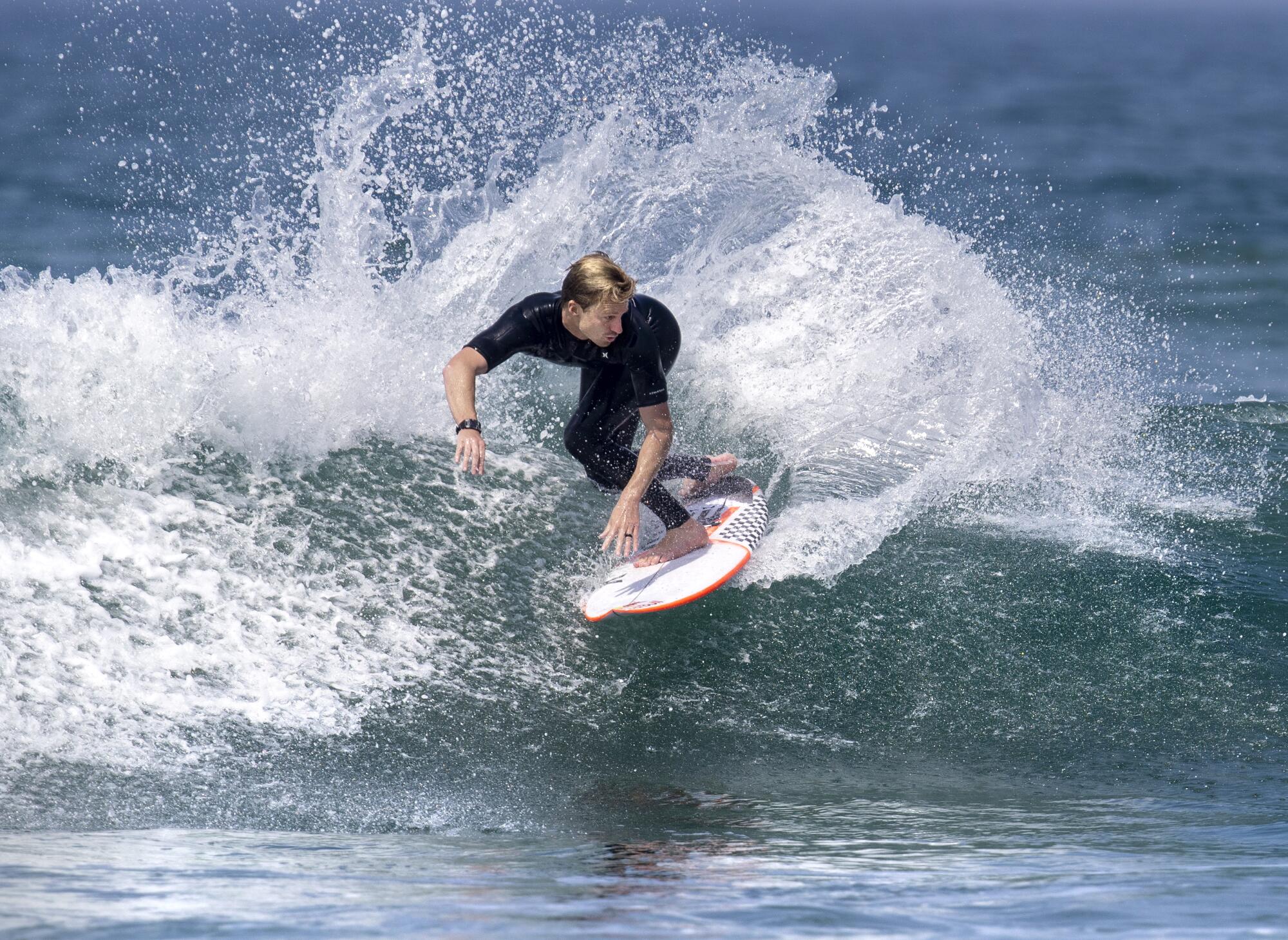 A surfer makes a slashing turn on a wave